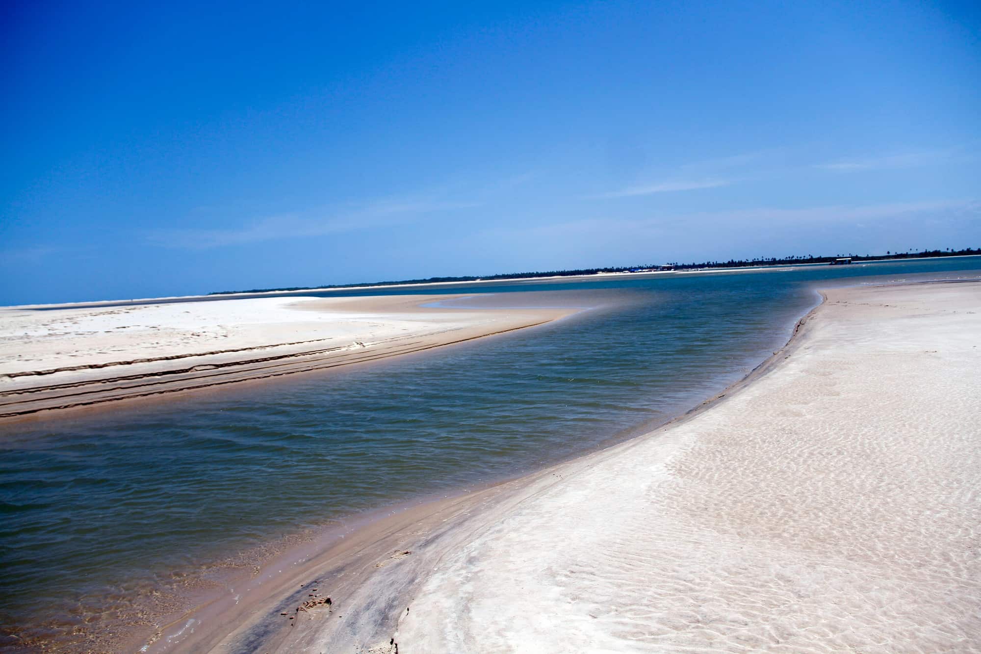 Faixa de areia branca da Ilha dos Namorados, em Aracaju, cercada de água azul